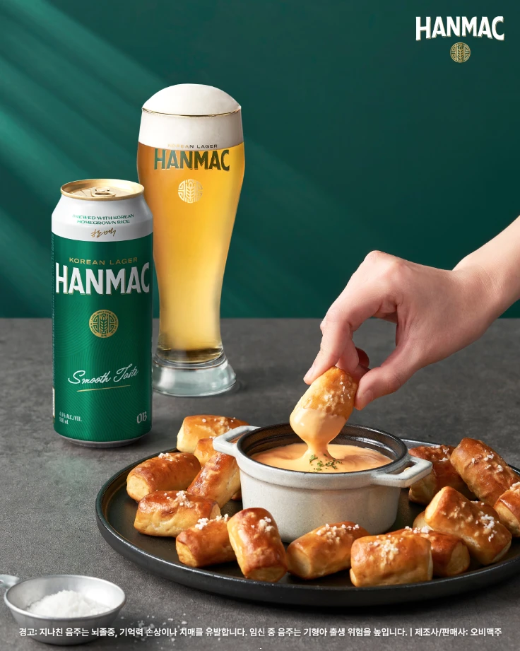 한맥 음식 디스커버리 두번째 에피스드 치즈 소스 프레첼 플레이팅과 500ml 맥주 캔이 있습니다.