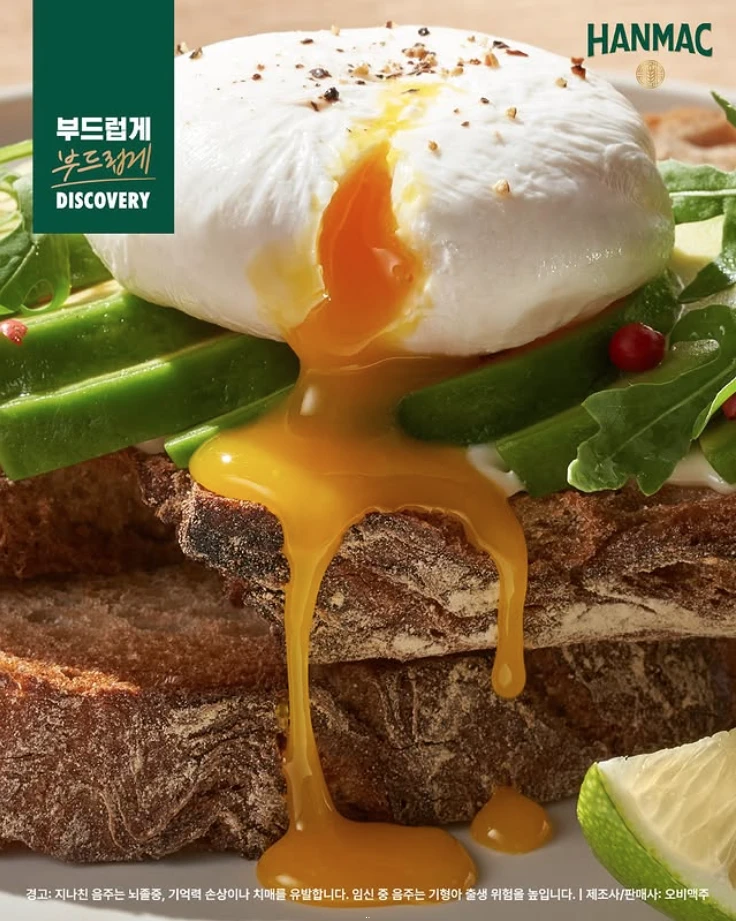 한맥 음식 디스터버리 다섯번째 에피소드 아보카도 에그 오븐 토스트에 디테일 컷으로 토스트 아보카드 계란 순으로 쌓여 노른자가 흐르고 있습니다.